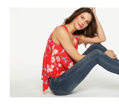 Row of assorted print and pastel pants folded at the knee. 